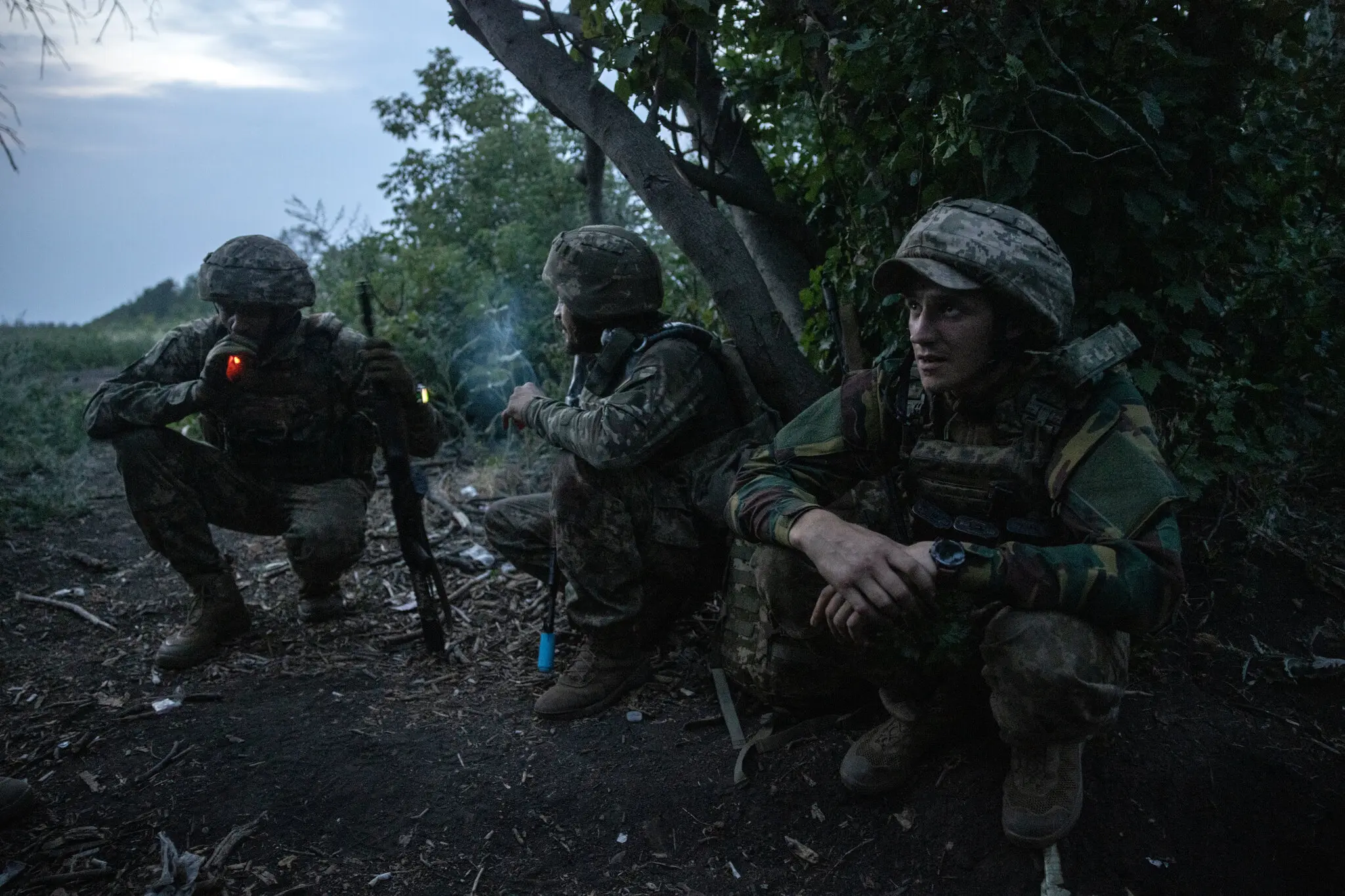 Бійці 58-ї бригади ховаються біля дерев на фронті проти російських військ.